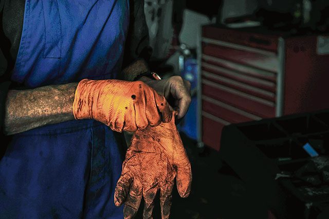 Retired Air Force Master Sgt. Greg Hermann, 86th Force Support Squadron Auto Hobby Shop tire technician, dons his gloves as he prepares for work Sept. 28 on Ramstein. Hermann has worked on Ramstein since April but carries over 40 years of auto mechanic experience with him.
