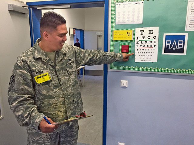 Tech. Sgt. Jeffrey Orina, U.S. Air Forces in Europe Civil Engineering, assists students with the eyesight portion of the health screening Sept. 19 at Ramstein Middle School.