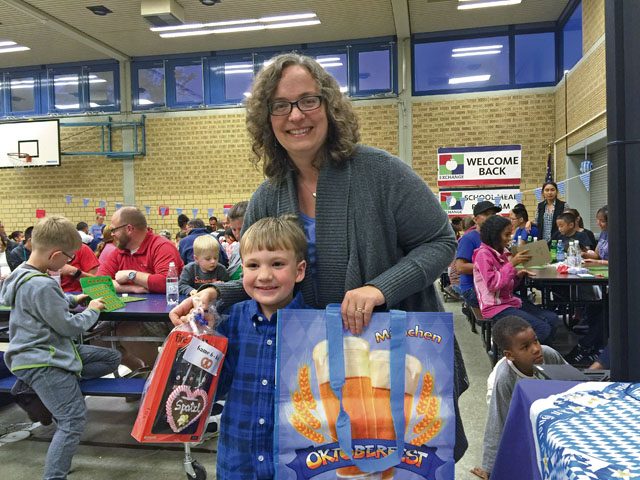 Sean Richesson poses for a photo with his mother Brenda Richesson after winning an electronic book reader at “Oktoberfest Family Bingo Night” Sept. 30 at Vogelweh Elementary School. Each game had two winners, a child and an adult. Prizes included German steins, electronic book readers and digital cameras.