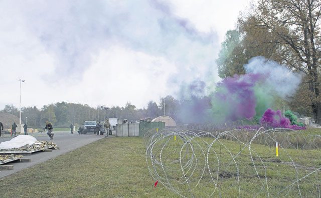 Green and purple smoke fills the sky as Airmen assigned to the 1st Combat Communications Squadron defend a base during a simulated attack during exercise Healthy Thunder Nov. 4 on Ramstein. In order to make the field training exercise portion of Healthy Thunder as real-world as possible, the Airmen used smoke grenades, ground burst simulators and blank rounds.