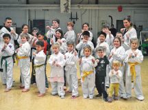Staff Sgt. Jon Garrett and his wife, Daniela, pose with students at their martial arts school, Legacy Sports School, in Mackenback. Jon and Dani currently offer a wide range of classes, including taekwondo and mixed martial arts.
