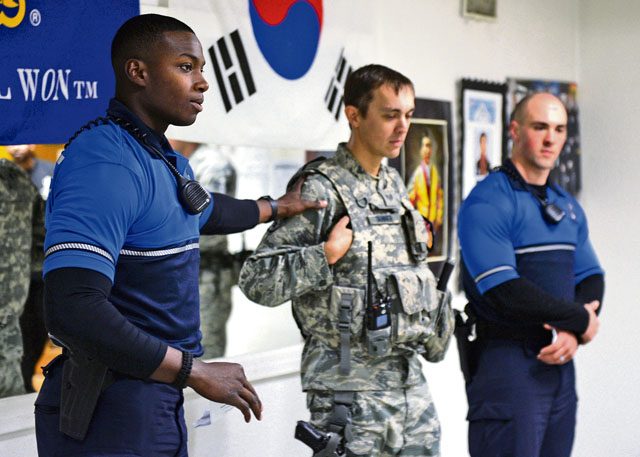 Airmen from the 86th Security Forces Squadron show children the different uniforms they wear Oct. 22 on Ramstein. Security forces typically wear two uniforms, which include the blue uniform for bike patrols and the Airman Battle Uniform for other duties.