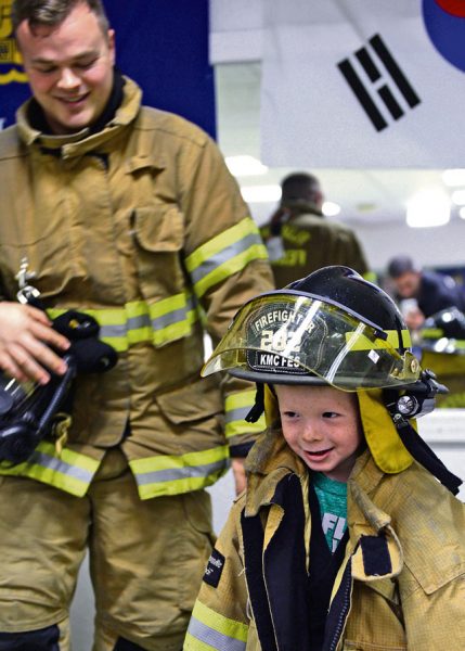 Cooper Yost, a member of the martial arts class, tries on firefighter equipment Oct. 22 on Ramstein. A firefighter donned full gear to show the children what they look like when responding to a fire.