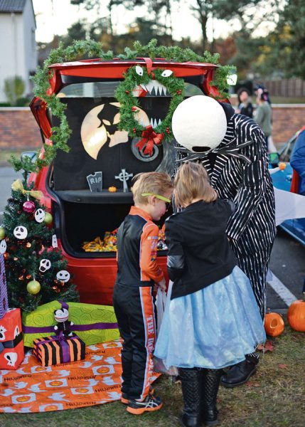 Photo by Senior Airman Jimmie D. Pike Staff Sgt. Brian Field, 86th Maintenance Squadron test measurement and diagnostic equipment technician, hands out candy while dressed as Jack Skellington Oct. 31 on Ramstein. Volunteers dedicated their time to set up, decorate and hand out candy to families for the annual Trunk or Treat event.