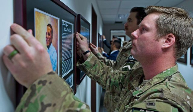 Special Agent Bradley Allen, 25th Expeditionary Field Investigation Squadron agent, hangs the portrait of a fallen Air Force Office of Special Investigations officer during the 25 EFIS’s fallen heroes dedication memorial Nov. 10 on Ramstein. The portraits contained biographies of the service member telling their story and the legacy they left behind. 