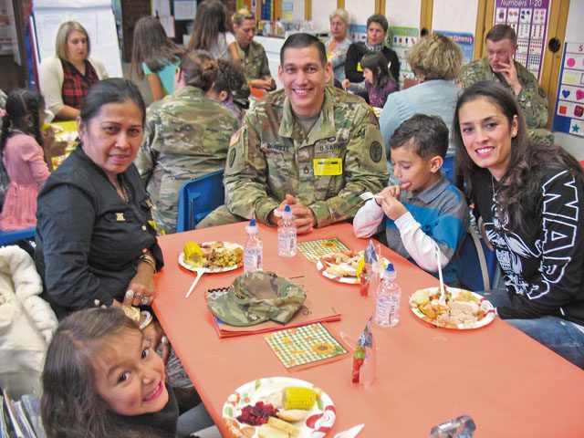 Kallum Ferrell and his family enjoy a Thanksgiving Feast Nov. 22 in Julie Wittenberg's first-grade class at Landstuhl Elementary Middle School. Before everyone ate, the students read and presented a pilgrim book to their families that they made that month.