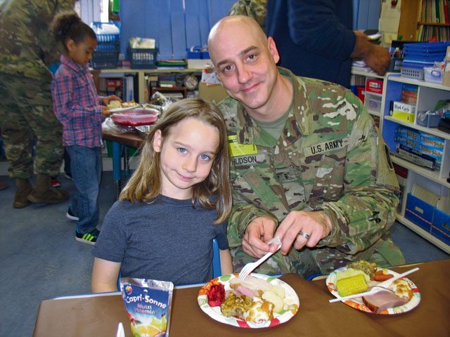 Parker Hudson and his dad, John Hudson, enjoy a Thanksgiving Feast Nov. 22 in Julie Wittenberg's first-grade class at Landstuhl Elementary Middle School. Before everyone ate, the students read and presented a pilgrim book to their families that they made that month.