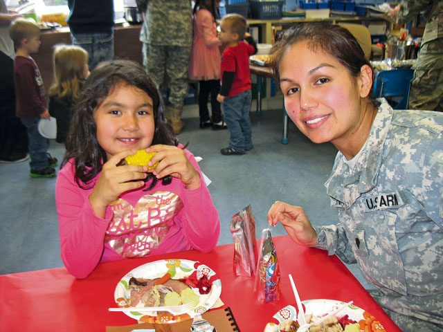 Hailey Soriano and her mom, Victoria Garth, enjoy a Thanksgiving Feast Nov. 22 in Julie Wittenberg's first-grade class at Landstuhl Elementary Middle School. Before everyone ate, the students read and presented a pilgrim book to their families that they made that month.