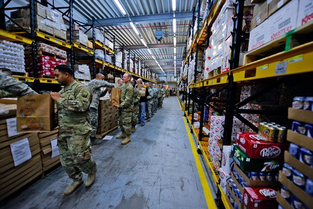 Airmen and Soldiers line up to fill bags with food and supplies at the Thanks for Thanksgiving event Nov. 19 on Vogelweh. KMC leaders banded together to support junior enlisted service members by providing them with all the fixings for a traditional Thanksgiving meal.