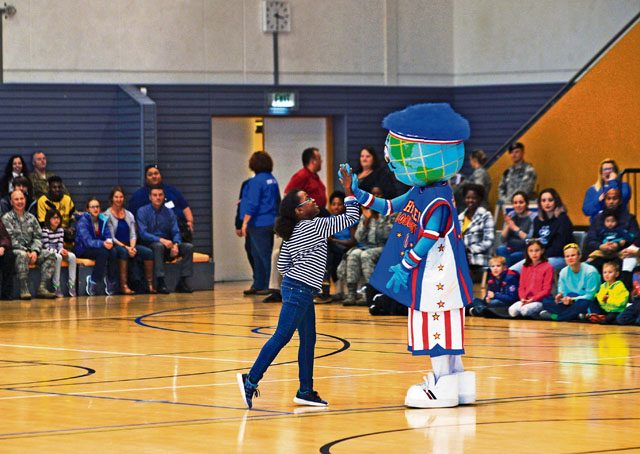 Globie, Harlem Globetrotters mascot, gives an audience member a high-five during a performance Nov. 10 on Ramstein. The 86th Force Support Squadron, Armed Forces Entertainment and Navy Entertainment brought the Harlem Globetrotters to Ramstein in order to boost the morale of Department of Defense members and their families. The basketball exhibition team combines elements of sports, theater and comedy to produce entertaining shows for its audiences.