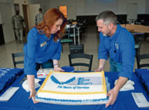 Juli Robertson, 86th Force Support Squadron community readiness specialist, and Wesley Yancey, 86 FSS exceptional family member program and family support specialist, place a cake on a booth celebrating the Air Force Aid Society’s 75th anniversary March 10 on Ramstein. Celebrations were held at the Kaiserslautern Military Community Center for families to come together in a large forum, and the event reminded people of the many different ways the AFAS helps Airmen and their families.