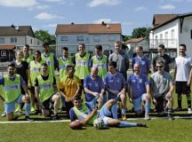 Ramstein Air Base Airmen and Fussballverein Ramstein Fussball Club A-Team pose for a photo during the Grassroots program sports day at FV Olympia Field June 24 in Ramstein-Miesenbach. More than 25 Airmen and soccer players volunteered for the event to help build relations between service members and the local community.