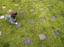 Cortlee Austin, Kaiserslautern Military Community member, cleans a gravestone March 10 at the American Kindergraves in Kaiserslautern. Between March and November, U.S. service members from the KMC area volunteer on a bi-weekly basis to maintain the Kindergraves by cleaning, mowing, and placing flowers on graves.