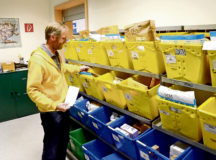 David Chinchen, USAG Rheinland-Pfalz Rhine Ordnance Barracks postal service employee, checks the small packages boxes for a customer’s mail at the ROB Postal Services Center package pickup window.