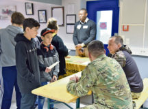 Teens speak to Capt. Brandon Dinger and Staff Sgt. William Reynolds, U.S. Army Garrison Rheinland-Pfalz Directorate of Emergency Services, at a career fair at Wetzel Teen Center in Baumholder on Nov. 22.