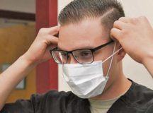 A dental assistant with the 319th Medical Group, demonstrates proper sanitary procedure by putting on a face mask at the medical treatment facility on Grand Forks Air Force Base, N.D. Photo by Airman 1st Class Elora J. Martinez