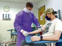 U.S. Air Force Staff Sgt. Randal L. Marks, 86th Medical Support Squadron chemistry and shipping noncommissioned officer in charge, prepares to take blood from Master Sgt. Marco Avecilla, 86th Airlift Wing Ramstein chapel superintendent, in the medical laboratory at Ramstein Air Base, June 8. Marks was awarded Airlifter of the Week for being the first medical laboratory technician to establish COVID-19 testing capabilities in West Africa for the Department of Defense.