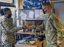 U.S. Air Force Chief Master Sgt. Josh Allen, 86th Comptroller Squadron chief enlisted manager, right, coins Tech. Sgt. Johne Tribble, 86th Airlift Wing Judge Advocate adverse actions noncommissioned officer in charge, for being named Airlifter of the Week at Ramstein Air Base, Germany, Sept. 10, 2020. Leadership awarded Tribble for her outstanding work ethic and drive that helped to ensure the uninterrupted legal proceedings of the Ramstein Legal Office (U.S. Air Force photo by Airman 1st Class John R. Wright)