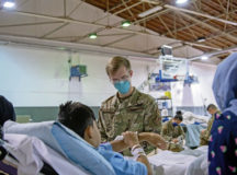U.S. Air Force Airman 1st Class Tyler Barnes, 48th Healthcare Operations Squadron aerospace medical technician, helps a patient at Ramstein Air Base, Germany, during Operation Allies Refuge, Aug. 27, 2021. Service members from the 48th HCOS work with Ramstein personnel to provide medical care to evacuees during the operation. (U.S. Air Force photo by Airman 1st Class Alexcia Givens)