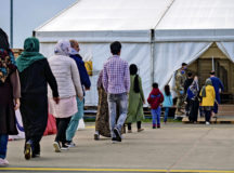 Evacuees are escorted into a tent where they will receive the COVID-19 vaccine at Ramstein Air Base, Germany, Sept. 26, 2021. Ramstein began the vaccination effort out of an abundance of caution to ensure the health and safety of the evacuees and local communities. (U.S. Air Force photo by Airman Jared Lovett)