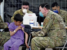 A U.S. Air Force Airman administers mumps, measles and rubella, and chickenpox vaccines to a child evacuee awaiting onward travel at Ramstein Air Base, Germany, Sept. 18, 2021. Ramstein established two centers where evacuees can volunteer to receive the vaccine to protect them from contracting MMR and varicella. Medical professionals administered varicella and MMR vaccines to more than 3,000 evacuees on the first day of mass vaccinations. (U.S. Air Force photo by Tech. Sgt. Devin Nothstine)