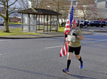 U.S. Air Force Master Sgt. Trevor Derr, 721st Aircraft Maintenance Squadron flight chief, runs with an American flag at Ramstein Air Base, Germany, Dec. 7, 2021. Derr originally began running as part of a New Year’s resolution to run 1,000 miles a year. After losing a friend who struggled with post-traumatic stress disorder, Derr shifted his goal to running with the flag and raising awareness for mental health. (U.S. Air Force photo by Airman 1st Class Madelyn Keech)