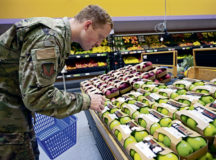 A U.S. Air Force Airman selects produce while grocery shopping at Ramstein Air Base, May 17. Service members and their families living overseas in certain areas will experience a reduction in their Overseas Cost of Living Allowance beginning June 1. The purpose of overseas COLA is to ensure that service members have the same purchasing power at overseas duty locations as in the U.S. Items such as groceries, car insurance, gasoline, and day care are taken into consideration when determining COLA rates.