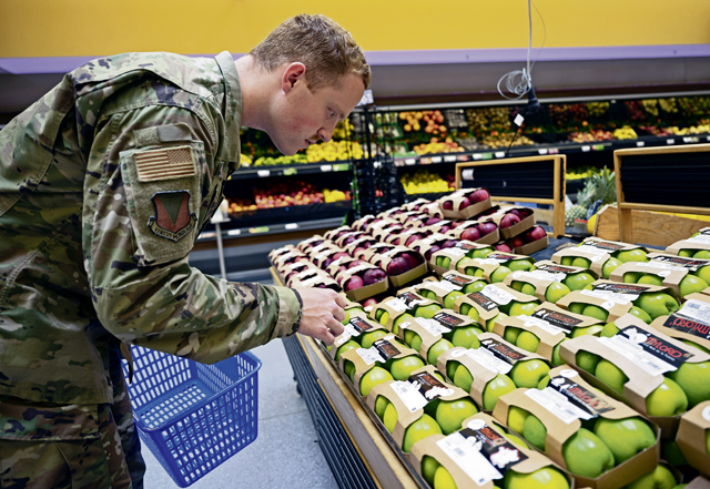 A U.S. Air Force Airman selects produce while grocery shopping at Ramstein Air Base, May 17. Service members and their families living overseas in certain areas will experience a reduction in their Overseas Cost of Living Allowance beginning June 1. The purpose of overseas COLA is to ensure that service members have the same purchasing power at overseas duty locations as in the U.S. Items such as groceries, car insurance, gasoline, and day care are taken into consideration when determining COLA rates.