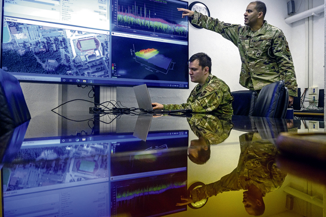 U.S. Air Force Tech. Sgt. Ricardo Hernandez, 1st Communications Maintenance Squadron network operations section chief, left, and Tech. Sgt. Chad Fisher, 1st CMXS unit training manager, discuss electromagnetic spectrum operations at Kapaun Air Station, Germany, April 5, 2022. In addition to providing traditional communications maintenance mission sets, the 1st CMXS enables warfighters to accomplish the 435th Air Ground Operation Wing’s Inside Out mission to get payloads on time, every time. (U.S. Air Force photo by Senior Airman John R. Wright)