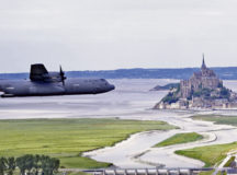 A C-130J Super Hercules aircraft assigned to the 37th Airlift Squadron out of Ramstein Air Base, Germany, flies past Mont Saint-Michel in Normandy, France, June 2, 2022. 37th AS has a lineage that stems from squadrons that participated in the invasion of France by dropping troops and carrying gliders over Normandy in order to secure towns and bridges before the rest of the Allied Forces could storm the beaches during World War II. (U.S. Air Force photo by Capt. Matt Bilbrey)