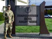 U.S. Air Force Tech. Sgt. MC Garrette Dela Cruz, 86th Airlift Wing administrative executive non-commissioned officer in charge, stands next to the 86th AW headquarters building sign at Ramstein Air Base, Germany, Nov. 16, 2022. Dela Cruz was recently awarded Airlifter of the Month for the hard work and dedication to his unit and for investing in the community as a task force leader for Armed Forces Against Drunk Driving and facilitating the most recent Ramstein Enlisted Summit. (U.S. Air Force photo by Airman 1st Class Madelyn Keech)
