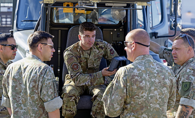 U.S. Air Force Senior Airman Ryan Downey, center, 86th Vehicle Readiness Squadron vehicle mechanic, provides information to Lithuanian airmen, with the Siauliai Air Base ground support unit, at Ramstein Air Base, Germany, Sept. 14, 2023. This collaboration ensured resources are used efficiently, benefiting both air forces and ultimately contributing to safer aviation operations. (U.S. Air Force photo by Senior Airman Edgar Grimaldo)