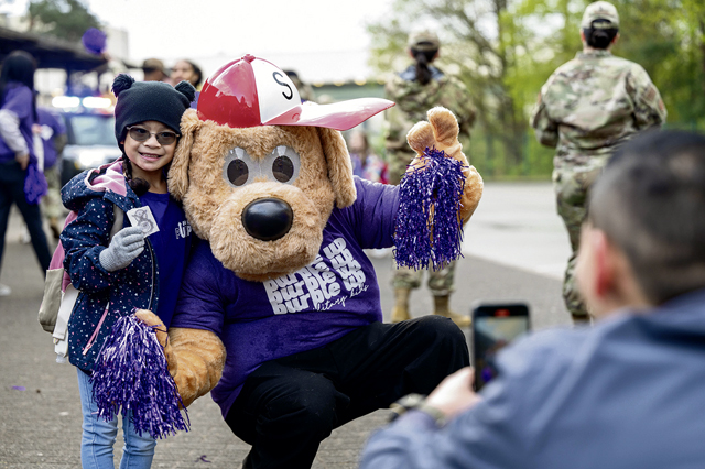 A father takes a picture of their child during the Purple Up! Day at Ramstein Air Base, Germany, April 17, 2024. Purple Up! Day  is an annual Department of Defense Education Activity designed to highlight the importance of providing children with quality services and support—helping them succeed in the mobile military lifestyle. (U.S. Air Force photo by Senior Airman Jordan Lazaro)