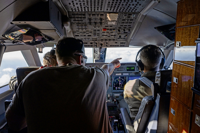 U.S. Air Force Tech. Sgt. Zachery Sewell, 76th Airlift Squadron flight engineer, points at another aircraft during a training flight at Ramstein Air Base, Germany, Nov. 21, 2025. The 76th AS conducts training flights to sustain global airlift readiness and ensure aircrews remain qualified to provide fast, executive-level transport for U.S., allied and partner leaders. (U.S. Air Force photo by Senior Airman Trevor Calvert)