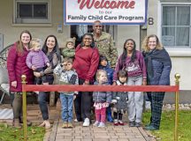 Personnel from the 86th Force Support Squadron, Family Child Care coordinators and children under the care of Maria Hamilton, center, an 86th FSS FCC provider, and Hamilton’s family, gather for a photo prior to a ribbon-cutting ceremony at Vogelweh Military Complex, Germany, Feb. 4, 2026. The ceremony celebrated the opening of a new FCC home, increasing access to safe, flexible child care for military families while supporting mission readiness and quality of life. (U.S. Air Force photo by Senior Airman Olivia Sampson)