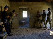 A member of the Hessian State Criminal Investigation Office instructs U.S. Airmen during a bilateral urban tactical and close-quarters training at the McCully Barracks Military Operations on Urban Terrain site, Germany, July 28, 2026. The realistic training environment allowed participants to practice movement through confined spaces, refine tactical decision-making and improve coordination with members of their host-nation counterparts. (U.S. Air Force photo by Senior Airman Brenden Beezley)