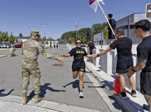 U.S. Army Staff Sgt. Ana Coba, a medical logistics sergeant assigned to Headquarters and Headquarters Company, 30th Medical Brigade, 21st Theater Sustainment Command, is congratulated at the finish line of the Back to School 5K, held on Sembach Kaserne in Sembach, Germany, Aug. 14, 2026. The run was held to commemorate another school year for the children of Soldiers and civilians working in the Kaiserslautern Military Community. (U.S. Army photo by Sgt. Elijah Campbell)
