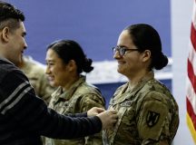 U.S. Army Chief Warrant Officer 2 Jessie M. Ramirez, a data operations warrant officer assigned to the 21st Theater Sustainment Command, receives her new rank insignia from her husband, John, during her promotion ceremony at Millrinder Hall on Panzer Kaserne, Kaiserslautern, Germany, Oct. 1, 2026. Ramirez was selected as a corporal through a pilot program that offered junior Signal Soldiers an opportunity to become warrant officers. (U.S. Army photo by Staff Sgt. Daniel Yeadon)
