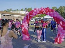 Kaiserslautern Military Community members pose beneath a breast cancer awareness arch before a 5K at Ramstein Air Base, Germany, Oct. 3, 2026. The event brought KMC members together to raise awareness and show support for those affected by breast cancer. (U.S. Air Force photo by Senior Airman Brenden Beezley)
